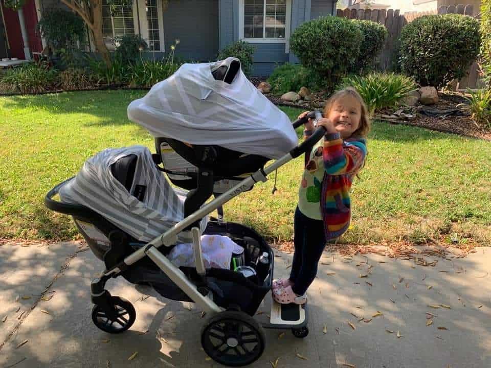 happy little girl riding in double mode UPPABaby Vista V2 stroller