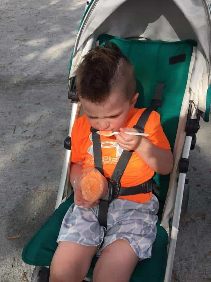 kid riding UPPAbaby G-Lite while eating