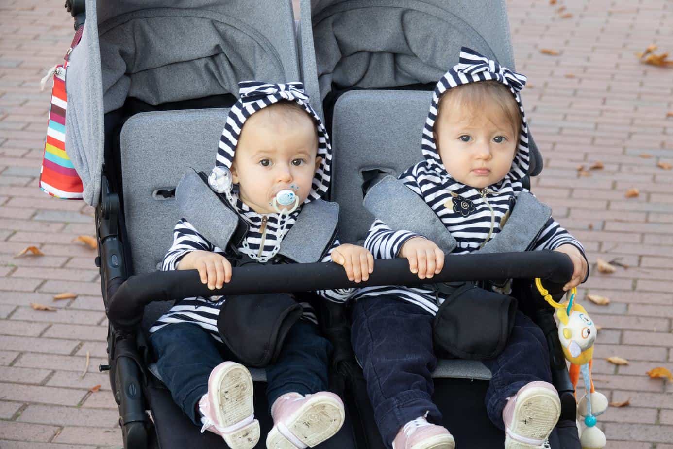 twin baby sitting in schwinn double jogging stroller