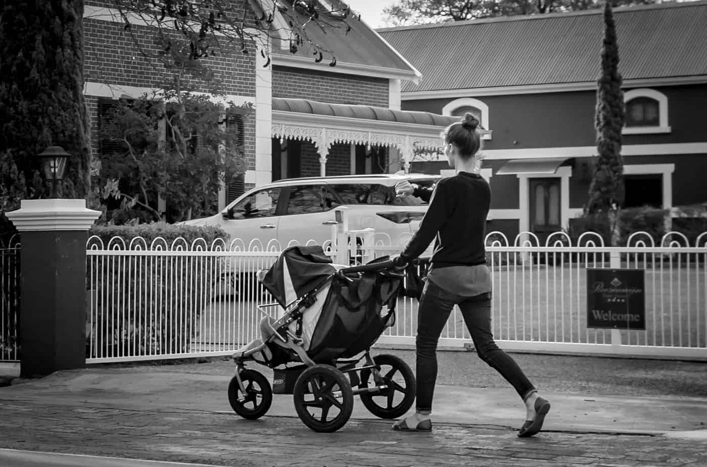 young mother walking with her child in stroller