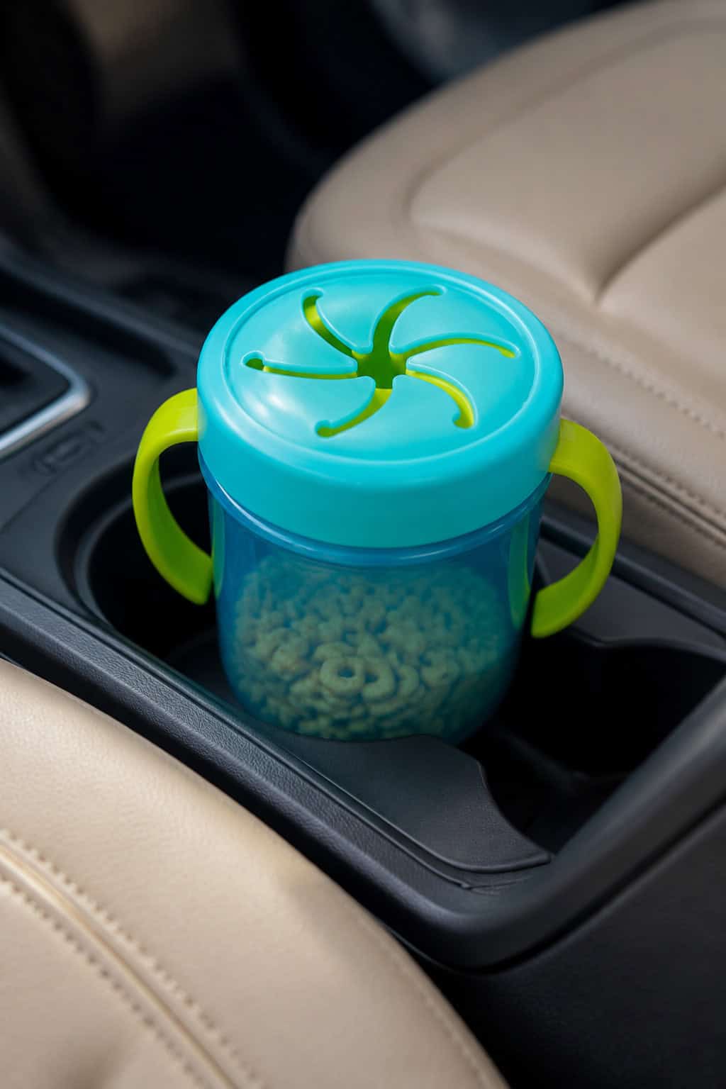 A spill-proof toddler snack cup sitting in a clean car cup holder