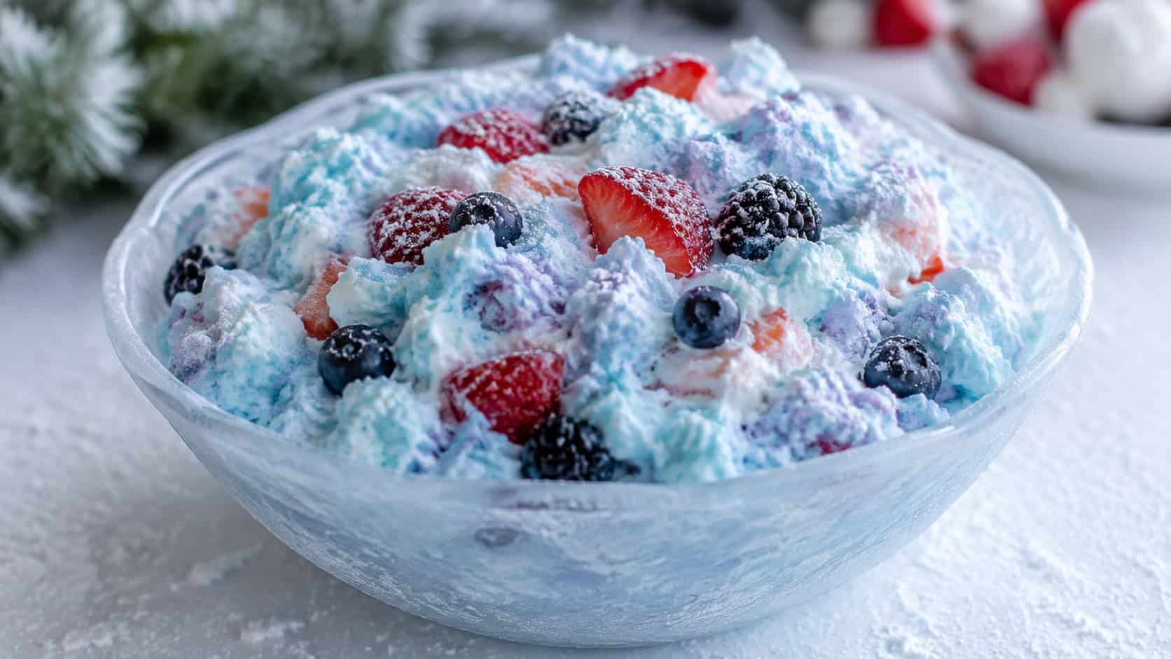 a fluffy pale-blue and white whipped berry jello salad studded with fresh berries, in a wide horizontal shot in a frosted glass bowl on a white table with a dusting of powdered sugar like snow, cool natural light, shallow depth of field, landscape orientation