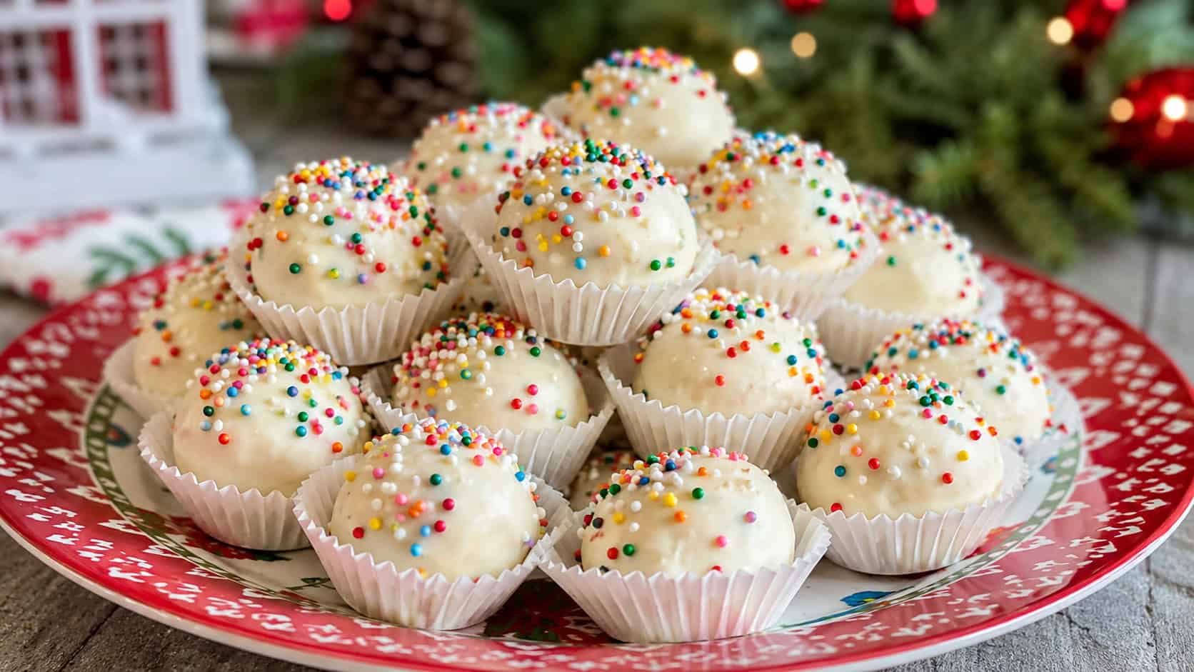 round white chocolate marshmallow truffles covered in colorful funfetti sprinkles, in a wide horizontal shot piled in mini paper cups on a bright festive platter with a soft holiday backdrop, natural light, shallow depth of field, landscape orientation