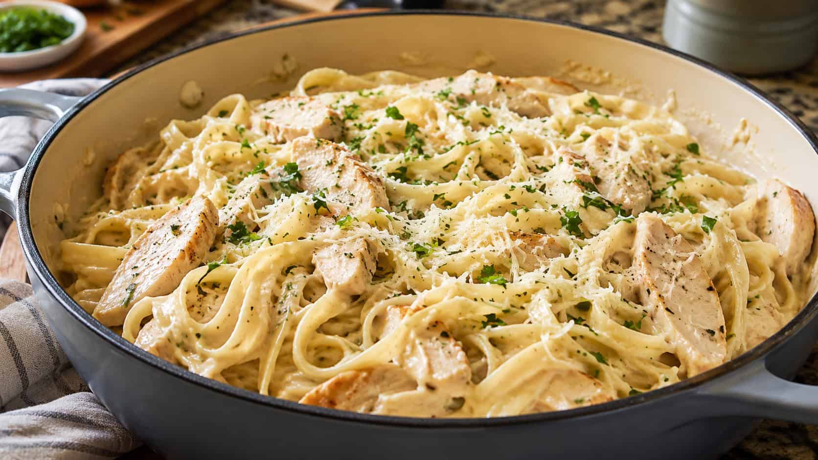 creamy chicken alfredo fettuccine twirled in a wide pot, sprinkled with parmesan and parsley, on a warm kitchen counter, natural light, shallow depth of field, wide horizontal landscape composition