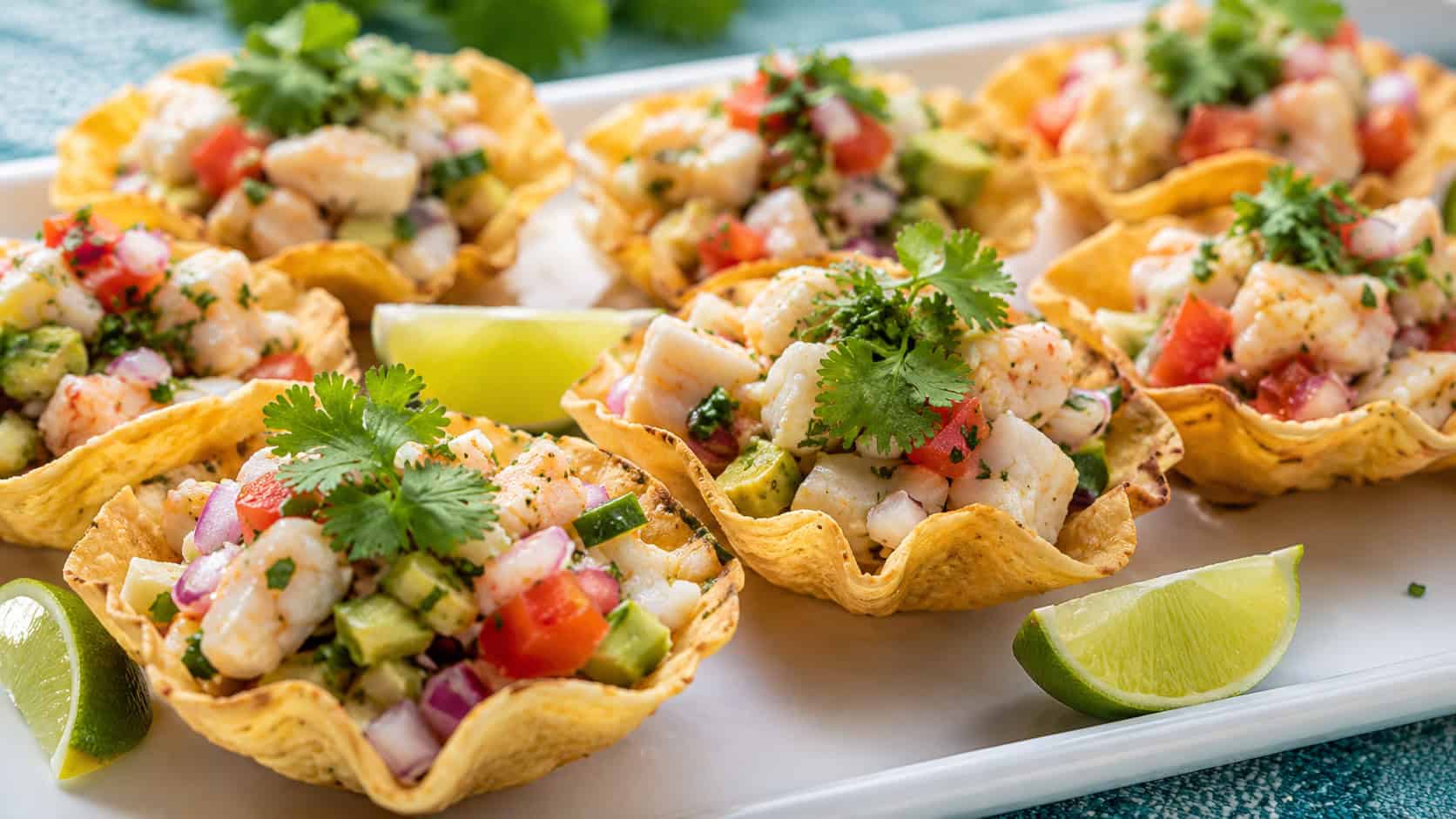 colorful seafood ceviche spooned into crisp tortilla cups with cilantro in a wide horizontal shot, on a bright platter with lime wedges, sunny fresh light, shallow depth of field, landscape orientation