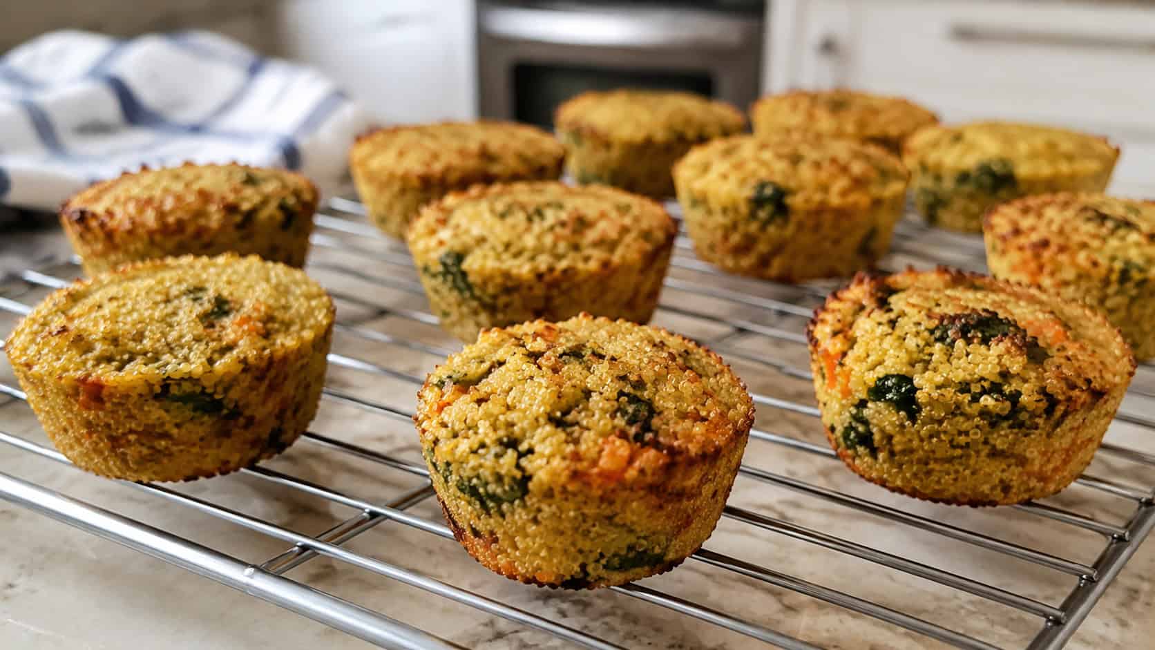 quinoa veggie cups in a wide horizontal shot, golden baked quinoa cups flecked with carrot and spinach on a cooling rack, natural light, shallow depth of field, landscape orientation