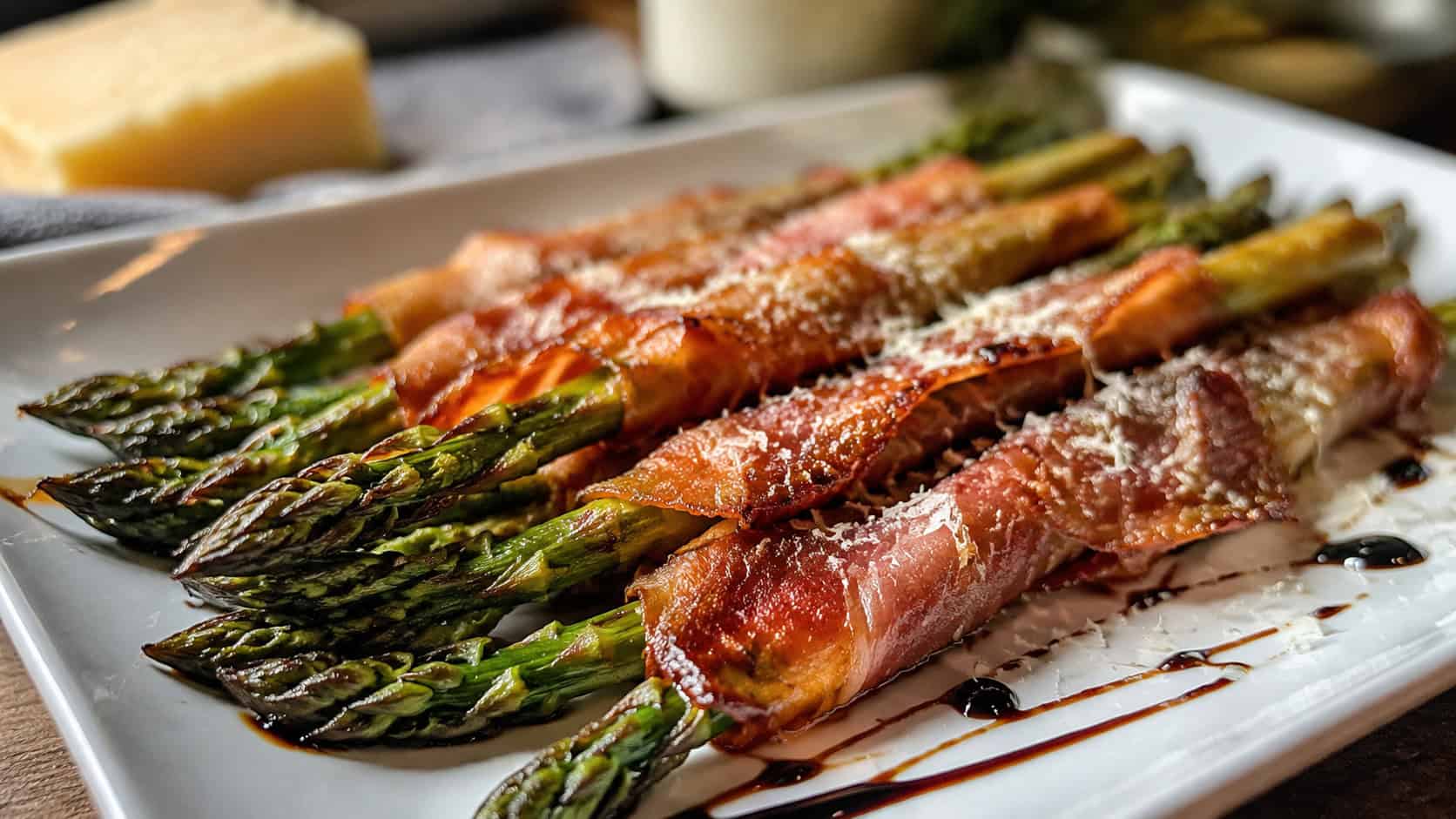 roasted asparagus spears wrapped in crispy prosciutto dusted with parmesan in a wide horizontal shot, on a platter with balsamic drizzle, natural light, shallow depth of field, landscape orientation