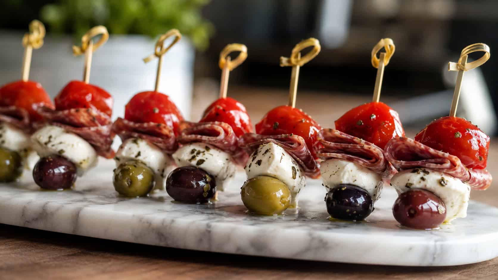 antipasto skewers with red cherry peppers, salami, mozzarella, and olives lined up on a marble board, in a wide horizontal shot, natural light, shallow depth of field, landscape orientation