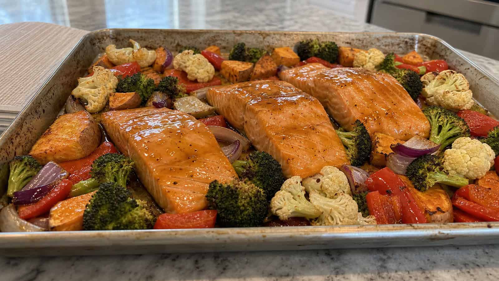 maple glazed salmon on a sheet pan with roasted vegetables in a home kitchen