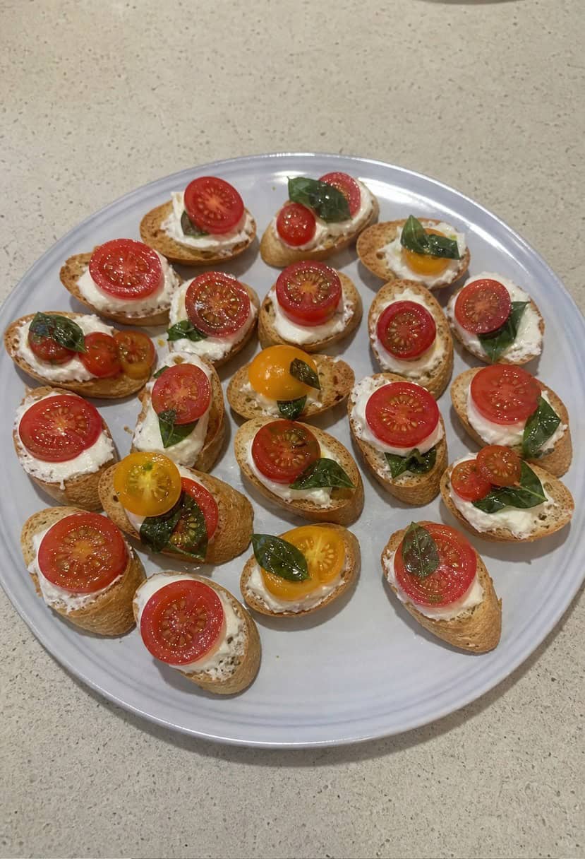 A rustic wooden table topped with a variety of bruschetta appetizers, including tomatoes, basil, and other fresh ingredients, arranged in an inviting and appetizing display