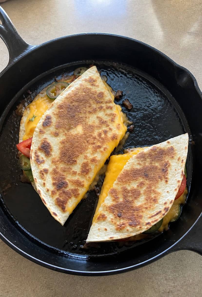 A sizzling cheese quesadilla on a hot skillet, surrounded by colorful ingredients like tomatoes, jalapeños, and cilantro