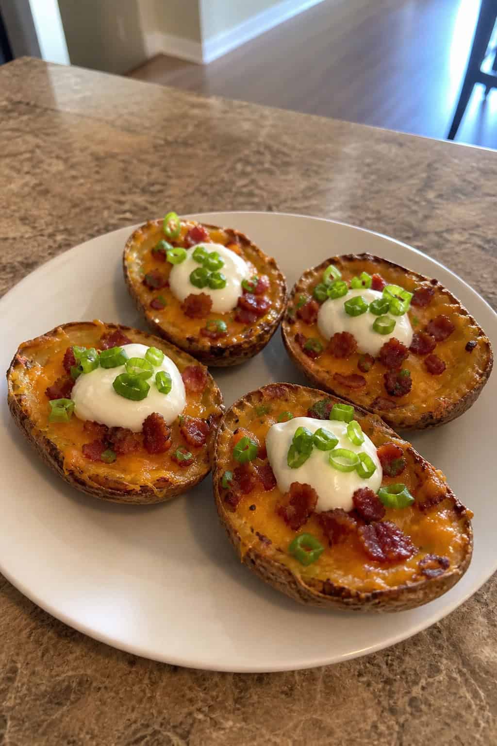 A serving board with several loaded potato skins topped with cheese, bacon, green onions, and sour cream.