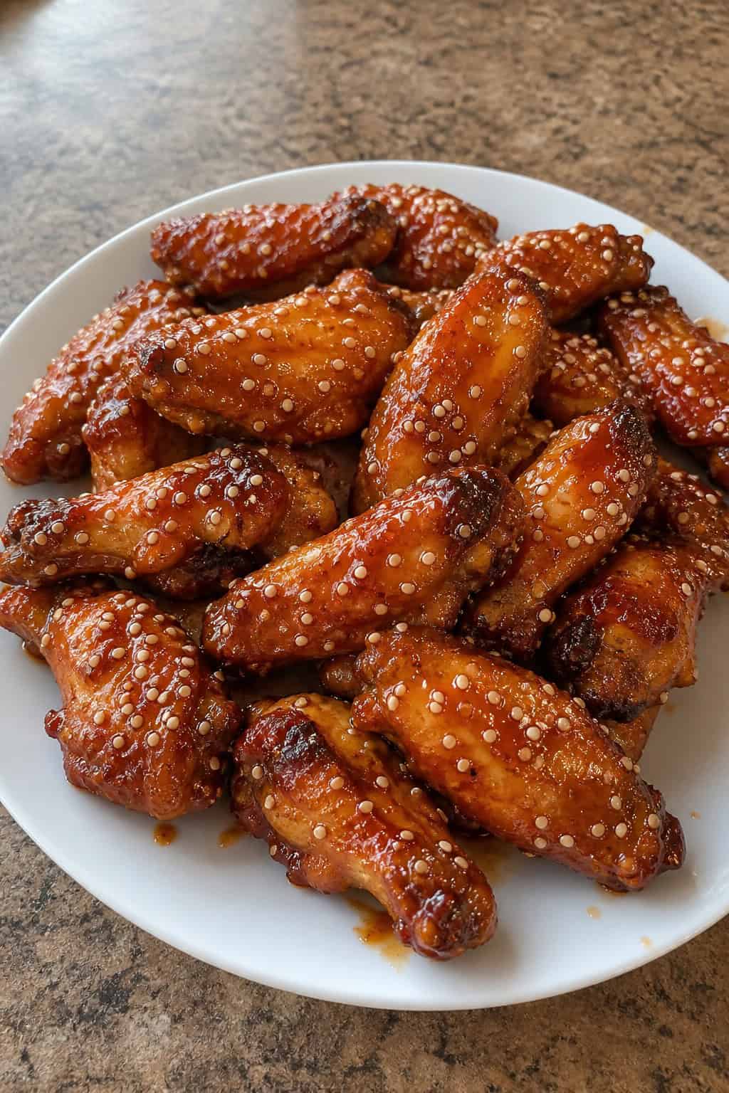 22 Chicken Wing Recipes for Game Day and Beyond 6 A plate of maple-sriracha chicken wings topped with toasted sesame seeds and fresh herbs.