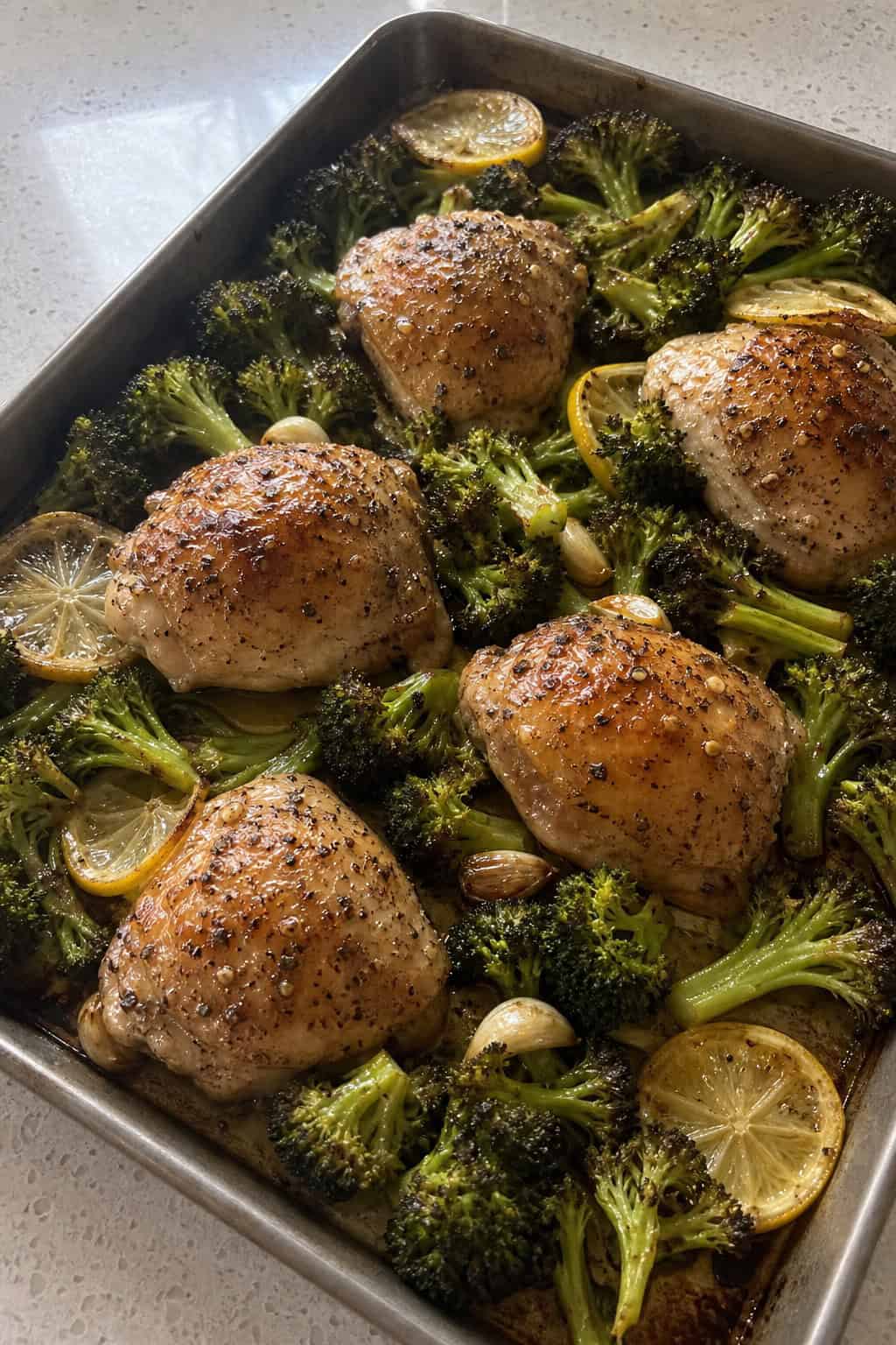 23 Healthy Chicken and Vegetable Recipes 2 A sheet pan with roasted lemon-garlic chicken thighs and broccoli florets.