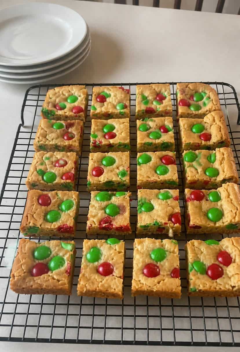 A festive kitchen counter with a batch of M&M Christmas cookie bars cooling on a wire rack, surrounded by holiday baking ingredients and utensils