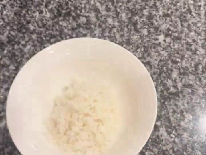 Cooked white rice in a white bowl, the first layer of the chicken teriyaki bowl.