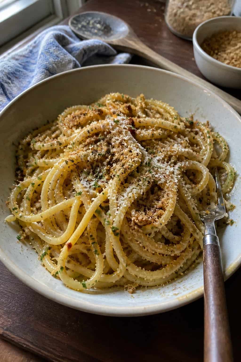 17 Pasta Dinners That Feel Fancy But Use Pantry Staples 9 A bowl of bucatini pasta topped with golden toasted breadcrumbs and flecks of fresh herbs