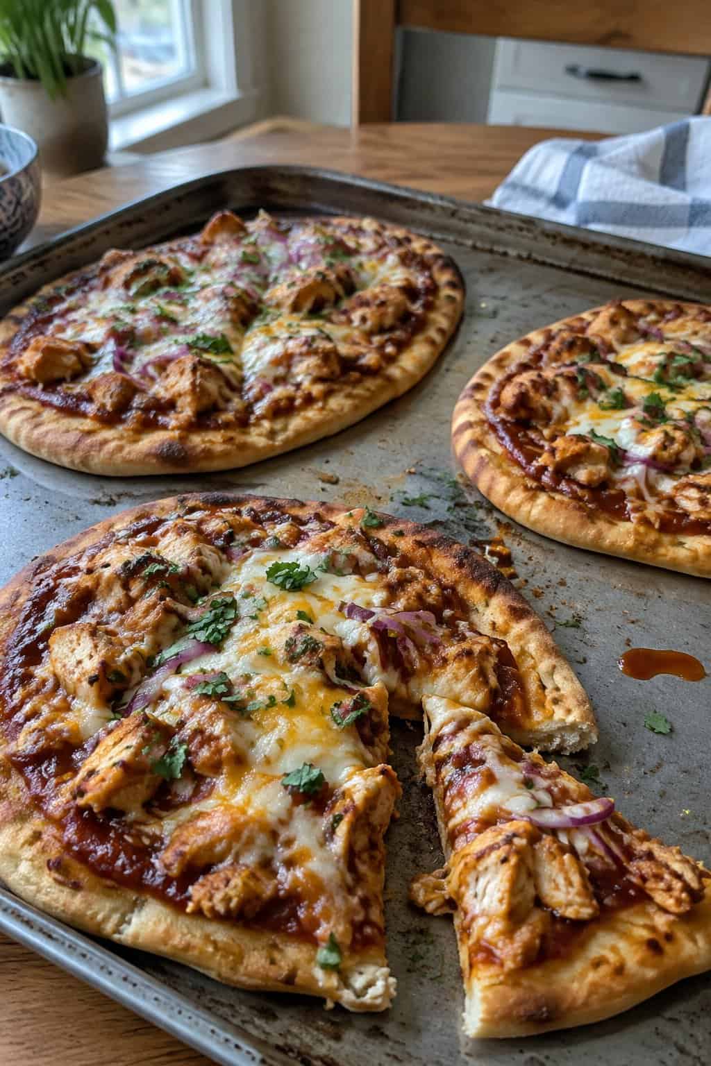 BBQ chicken flatbread pizzas topped with melted cheese and red onion.