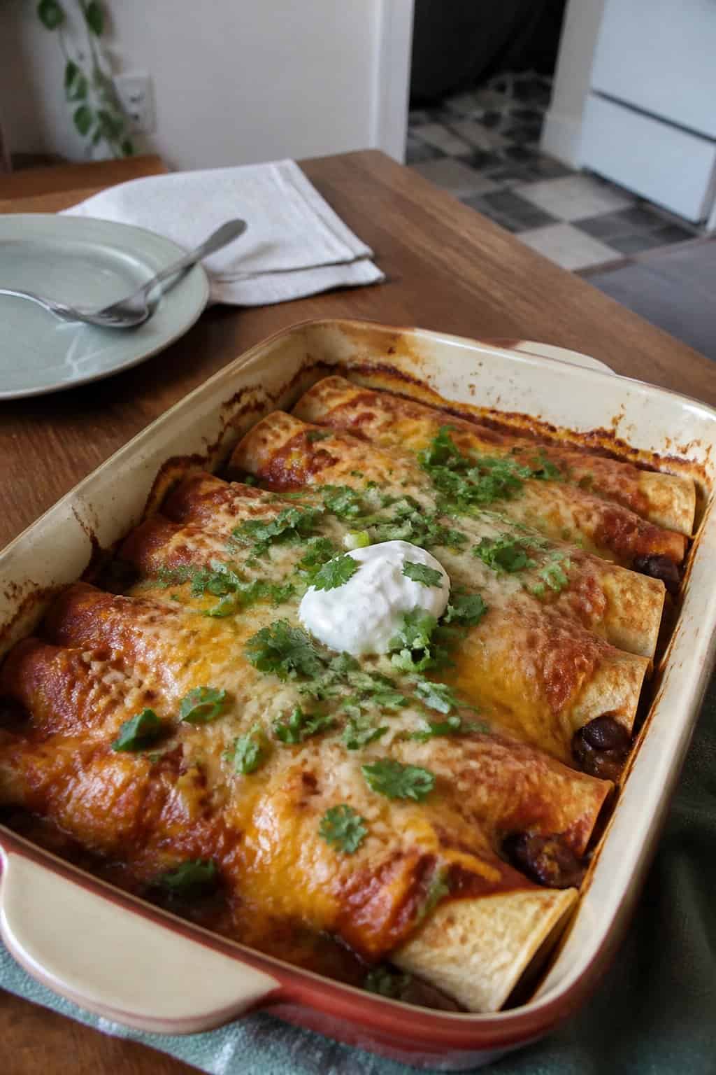 17 Budget Dinners That Use What You Already Bought 16 A baking dish of bean and cheese enchiladas with melted cheese and simple garnishes.