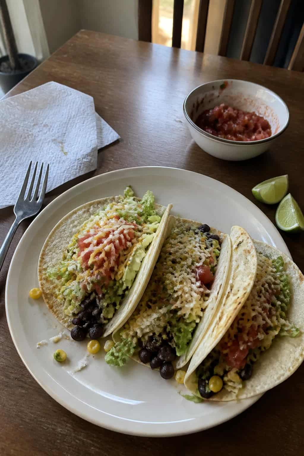 17 Budget Dinners That Use What You Already Bought 6 A plate of black bean and corn tacos topped with salsa and a lime wedge.