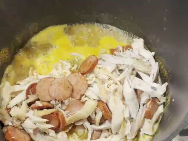 Rotisserie Chicken and Andouille Jambalaya with Boxed Rice Mix 5 Shredded chicken and sausage pieces poured into a pot with melted butter and seasonings.