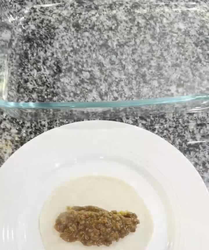 A spoonful of chili beef enchilada filling on a small low-carb tortilla on a white plate