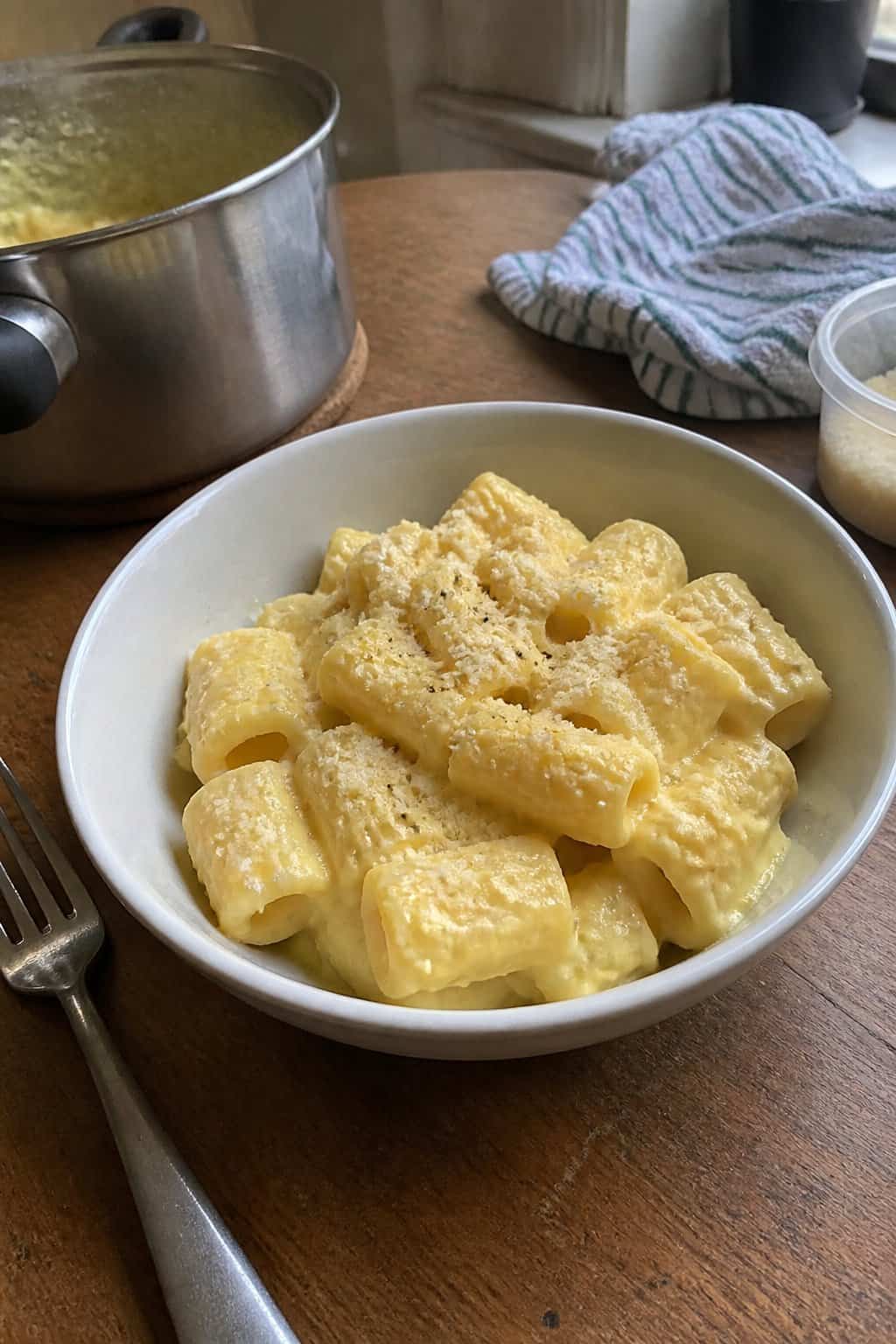 17 Pasta Dinners That Feel Fancy But Use Pantry Staples 17 A bowl of creamy cornmeal-based pasta topped with a generous layer of grated Parmesan