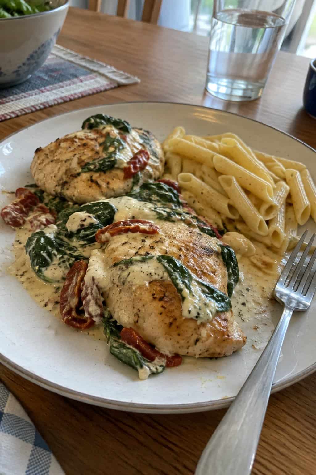 Creamy chicken with spinach and sun-dried tomatoes served on a plate.