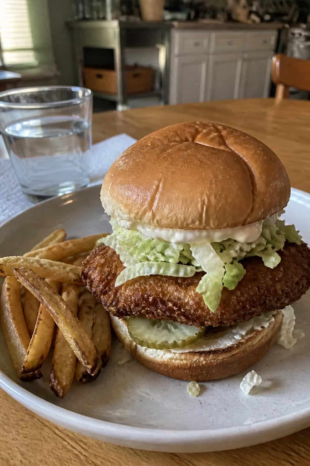20 Copycat Chicken Recipes for Restaurant Cravings at Home 21 A crispy chicken sandwich with lettuce and pickles on a plate beside fries.