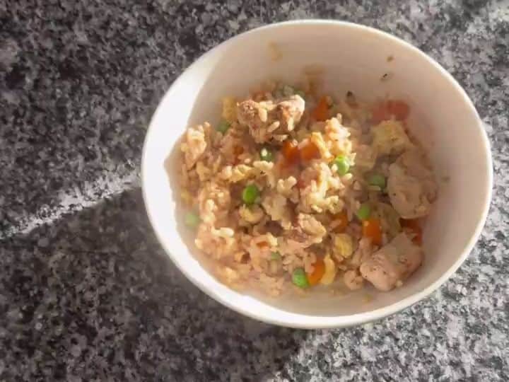 Easy Chicken Fried Rice 6 A white bowl filled with finished chicken fried rice sits ready to serve on the counter.