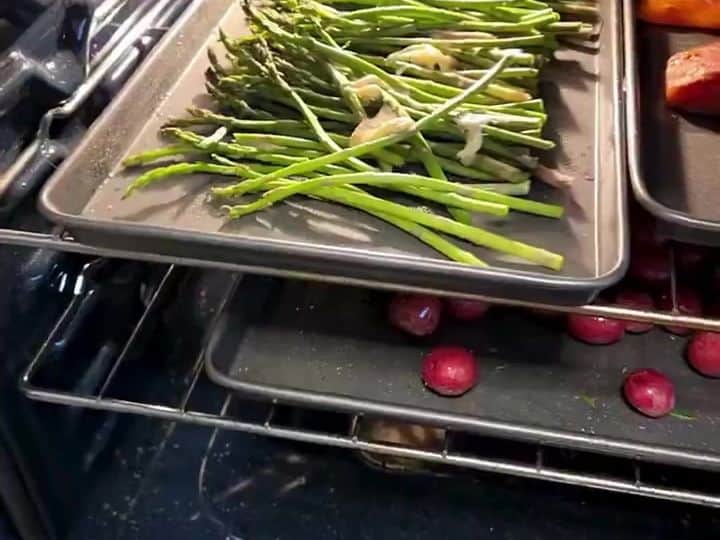 Roasted Salmon with Lemon-Pepper Asparagus and Potatoes 5 An oven interior with sheet pans of asparagus and potatoes roasting inside.