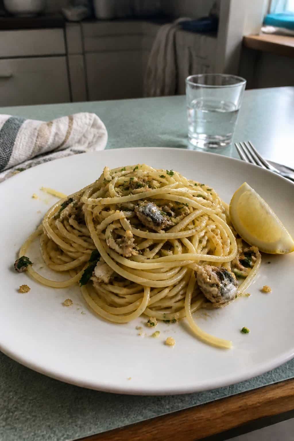 17 Pasta Dinners That Feel Fancy But Use Pantry Staples 16 A plate of spaghetti tossed with sardines, parsley, breadcrumbs, and a wedge of lemon on the side