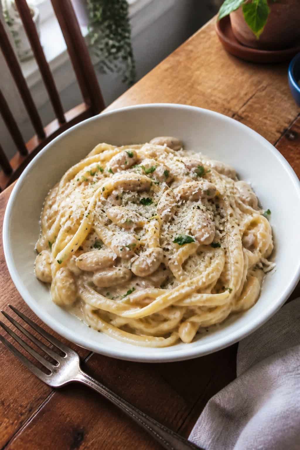 17 Pasta Dinners That Feel Fancy But Use Pantry Staples 13 A bowl of creamy garlic pasta made with blended white beans, topped with black pepper and herbs