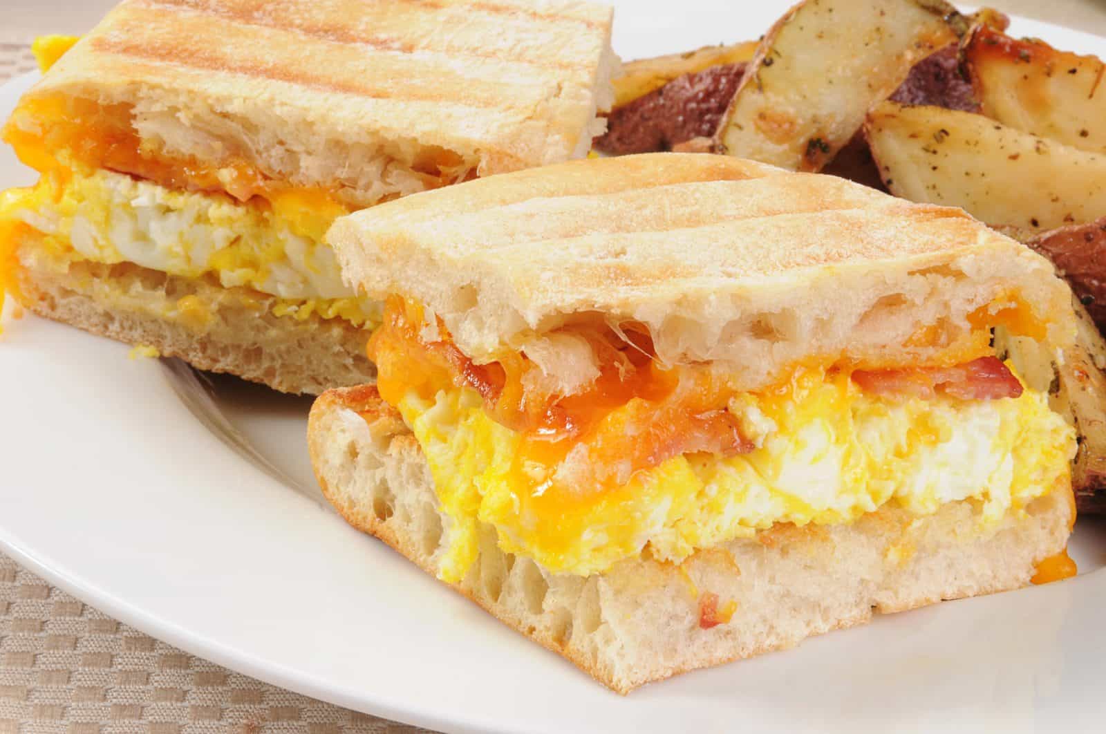 Copycat Breakfast Recipes for Slow Weekends 6 Scrambled egg, bacon and melted cheese in toasted rectangular bread, served with potato wedges.