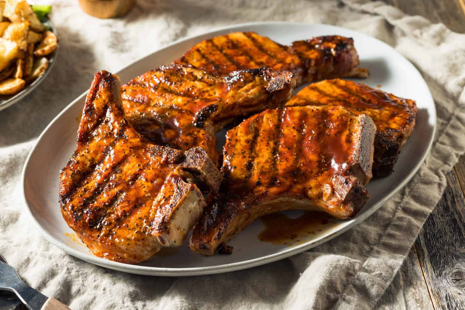 Crockpot Boneless Pork Chop Recipes for Hungry Families 14 BBQ Pork Chops with Corn on a plate