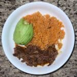 Carne asada, Mexican rice, avocado slices in a blate