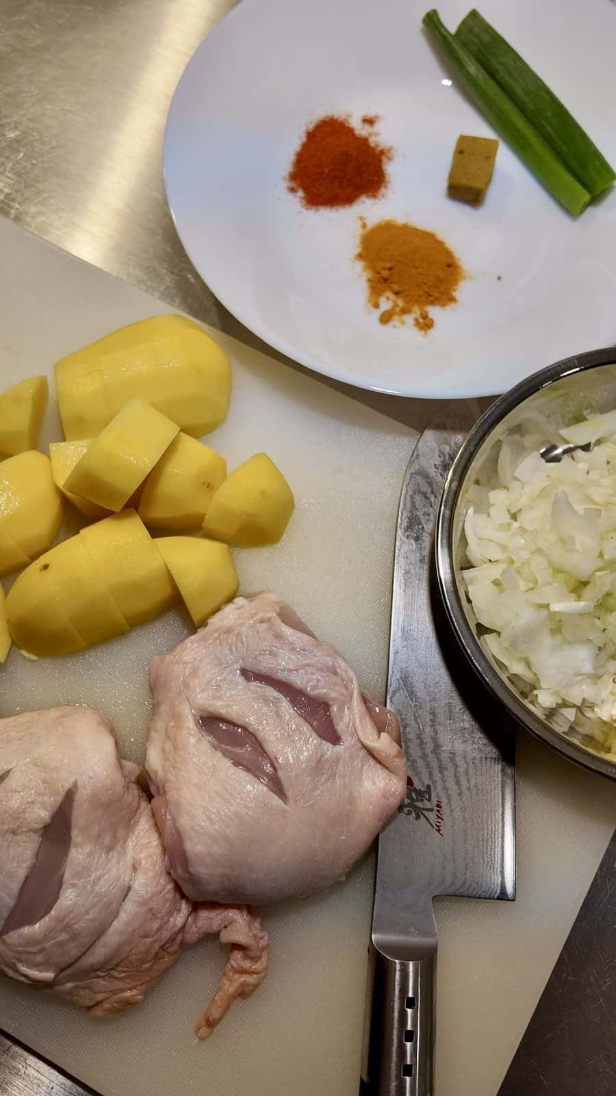 Chicken is scored and potatoes are cut