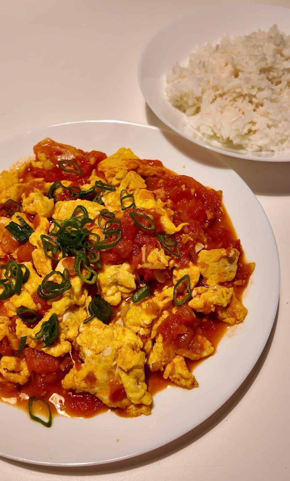 Finished Tomato and Egg over a bowl of white rice
