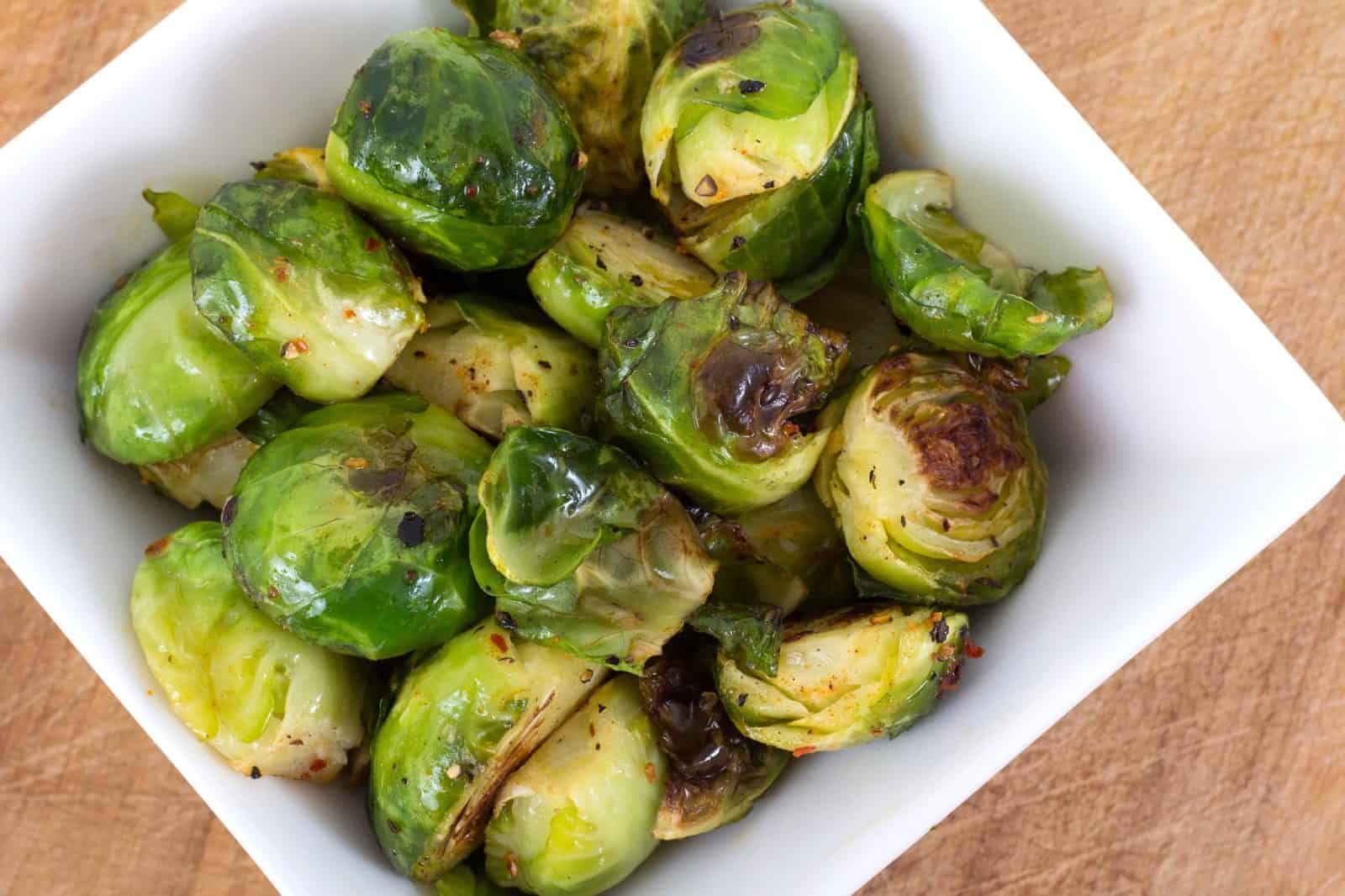 Vegan Appetizers That Disappear Fast at Parties 18 9) Maple-Sriracha Brussels Sprouts on a plate