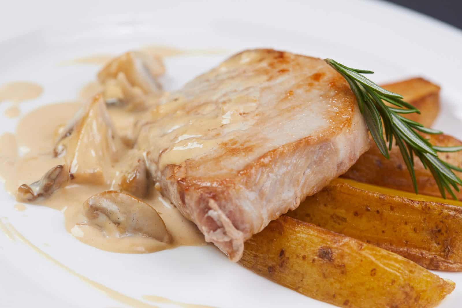 Crockpot Boneless Pork Chop Recipes for Hungry Families 26 Pork Chops with Mushroom Gravy on a plate