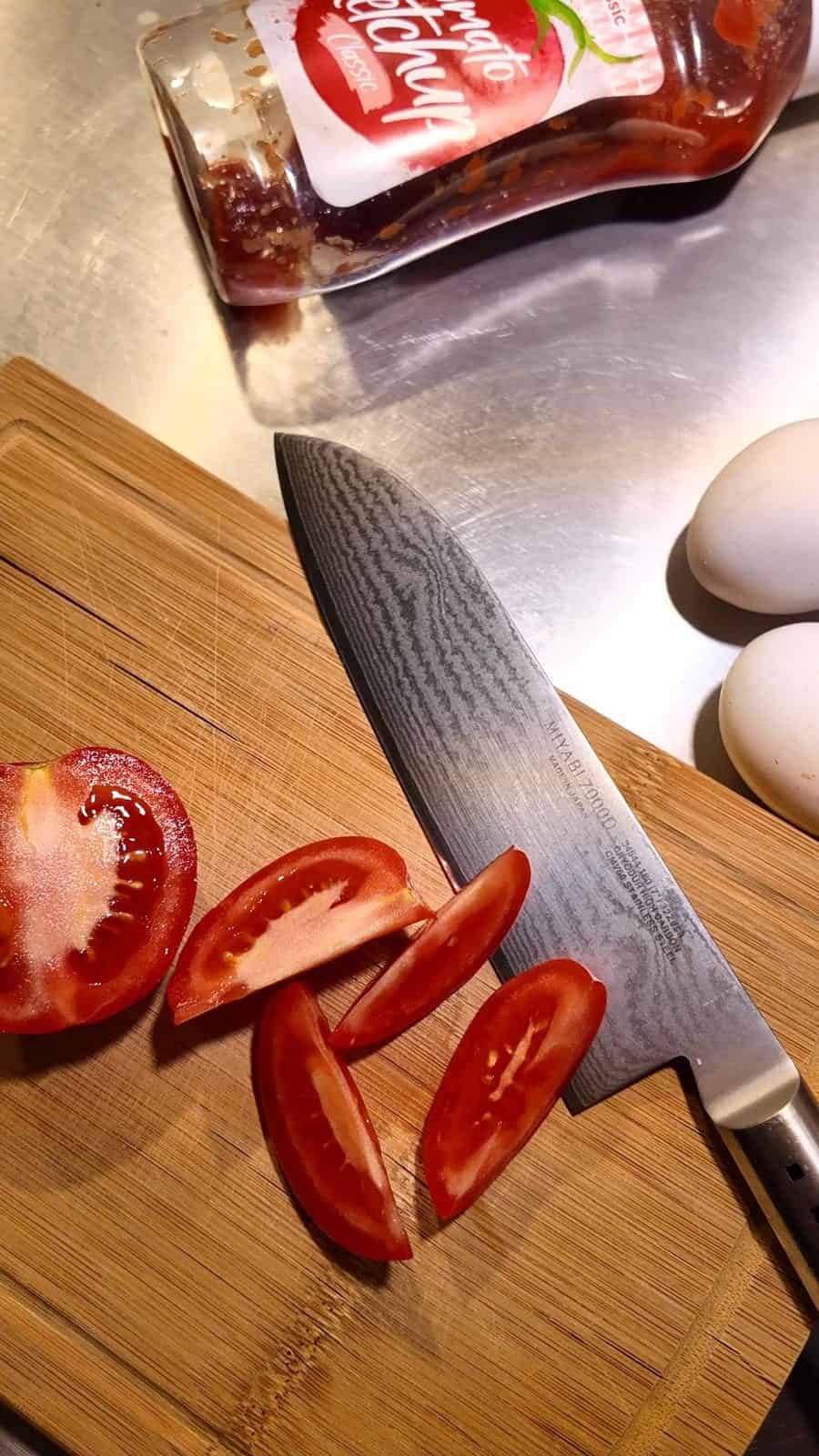 Sliced tomato wedges with ketchup used in the background